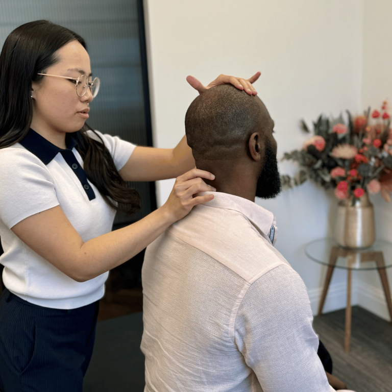 Chiropractor assessing a patient’s neck for neck pain at Mayfair & Belgravia Chiropractic