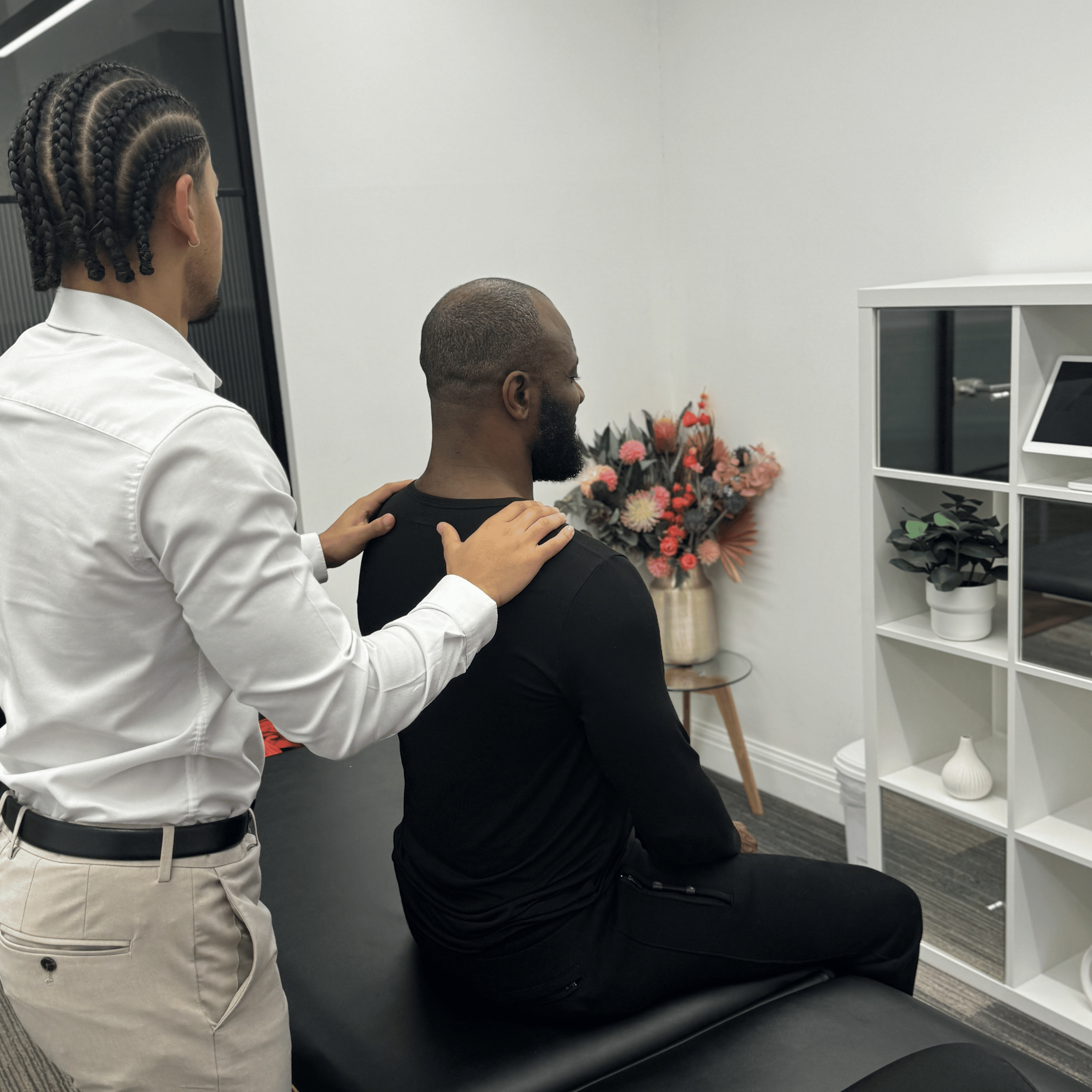 Chiropractor assessing a patient’s posture and shoulder alignment at Mayfair & Belgravia Chiropractic